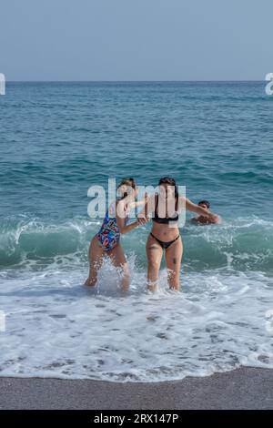 Spiaggia di Malagueta a Malaga alla luce del sole autunnale. Cielo blu sopra. Gente che prende il sole sotto il cielo blu della costa del sol. Foto Stock