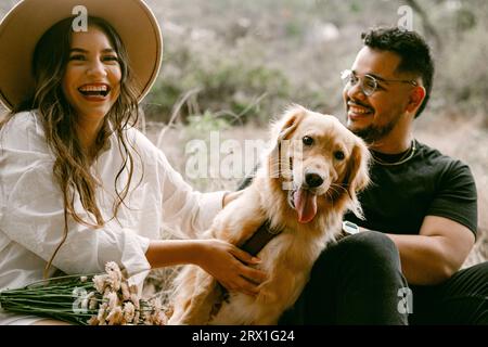 Giovane coppia che si diverte con il cane domestico Foto Stock