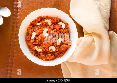 Gajar Halwa o Carrot Halwa, tradizionale dolce invernale indiano, dessert guarnito con mandorle, uvetta, noci. Preparato durante Diwali, Dussehra e Navratra Foto Stock