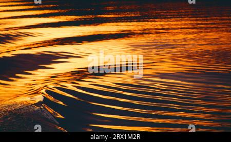 Sonnenuntergang auf der Wolga, Heckwellen eines Schiffes im Gegenlicht * onde di una nave sul fiume volga al tramonto arancione Foto Stock