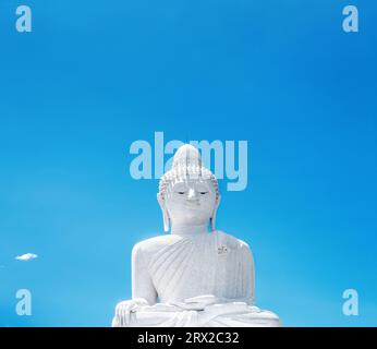 Statua di marmo bianco del grande Buddha a Phuket, Thailandia. Monumento gigante del Buddha su sfondo blu del cielo Foto Stock