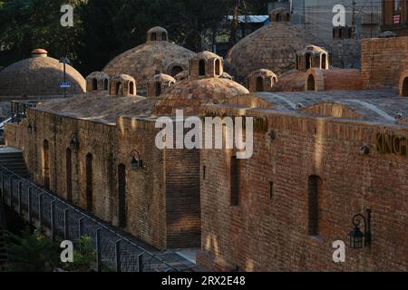 Lo storico quartiere della città vecchia nel centro di Tbilisi. La capitale georgiana al mattino in una giornata di sole. Splendidi edifici in mattoni e tetti a cupola Foto Stock