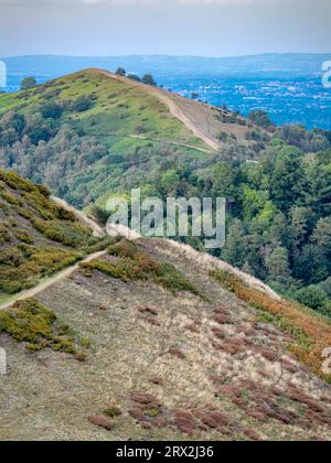 Gli escursionisti in lontananza si trovano in cima all'Herefordshire Beacon, guardando verso nord, verso le iconiche vette delle Malvern Hills e del Worcestershire Beaco Foto Stock