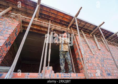 Contea di Luannan, Cina - 28 settembre 2022: I lavoratori edili stanno adeguando il modello di costruzione in un cantiere, nella Cina settentrionale Foto Stock