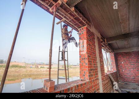 Contea di Luannan, Cina - 28 settembre 2022: I lavoratori edili stanno adeguando il modello di costruzione in un cantiere, nella Cina settentrionale Foto Stock