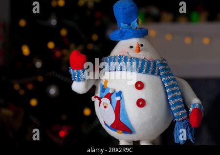 pupazzo di neve sotto l'albero in uno sfondo natalizio Foto Stock