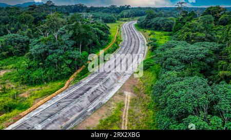 Autostrada vuota nella giungla, futura capitale Ciudad de la Paz, Rio Muni, Guinea Equatoriale, Africa Foto Stock