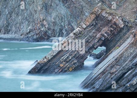 Una vista al crepuscolo di un arco roccioso formato da strati di rocce sedimentarie, a Hartland Quay, sulla costa atlantica del Devon, Inghilterra, Regno Unito, Europa Foto Stock