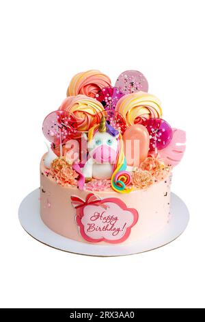 Torta di compleanno rosa con simpatici unicorno fondente, lecca lecca, ghiaccioli e testo Happy Birthday su un foglio commestibile isolato su sfondo bianco Foto Stock