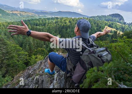 Escursionista che riposa in cima alla montagna con una splendida vista Foto Stock