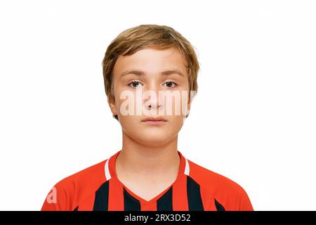 Ritratto ravvicinato di un ragazzo adolescente di 12 - 13 anni che indossa l'uniforme da calcio Foto Stock