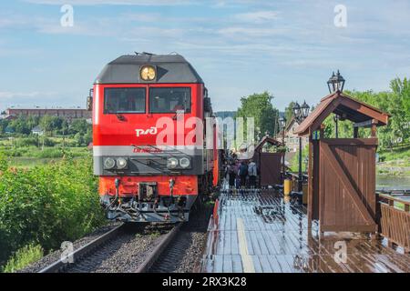 Sortavala, Russia - 15 luglio 2023: Il treno passeggeri si avvicina alla piattaforma di legno. Foto Stock