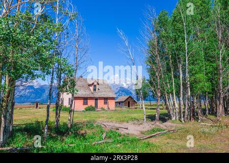 Azienda abbandonata edificio su 'Mormon Row' all'Grand Tetons Mountain Range in background, che si trova nel Grand Tetons National Park in Wyoming. Foto Stock