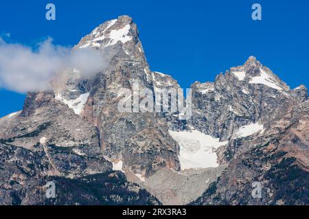 Basse nuvole e nebbia creano la catena montuosa dei Grand Tetons alla luce del mattino presto. Questa montagna è la più giovane delle Montagne Rocciose. Foto Stock