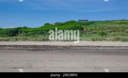 Low Newton, Regno Unito - 13 luglio 2023: Rifugi sulla costa del Northumberland Foto Stock