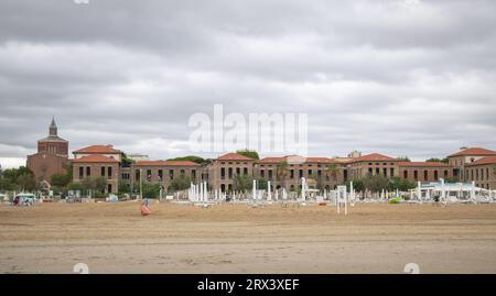 Rimini, Italia - 5 agosto 2023 Vista della spiaggia di Rimini in una giornata nuvolosa. di fronte a vecchi edifici. Foto Stock