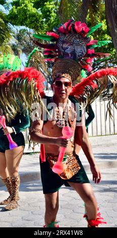 La parata del Carnevale di San Pedro Town del 2023. Frequentatori del Carnevale vestiti con costumi verdi e rossi e danzanti lungo il percorso della sfilata. Foto Stock