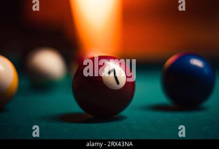 Foto dettagliata di palline da biliardo su un accogliente sfondo caldo con illuminazione arancione. Immagine ravvicinata di palline da biliardo colorate. Foto Stock