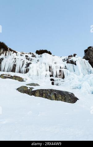 Cascata ghiacciata Skok in alta Tatra (Slovacchia) in inverno. Grande cascata con ghiaccio gigante blu sulle rocce. Foto Stock