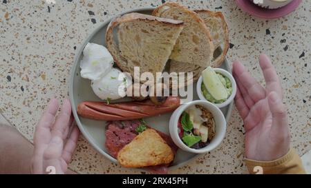 Tradizionale colazione britannica in un piatto preso da un uomo. Una colazione ravvicinata. Foto Stock