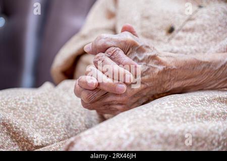 Le mani di una vecchia donna si sono stropicciate, sentendosi sole senza suo marito Foto Stock