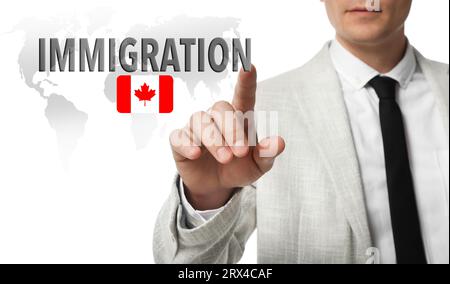 Immigrazione. Uomo d'affari che tocca lo schermo digitale con la parola e la bandiera del Canada su sfondo bianco, primo piano Foto Stock