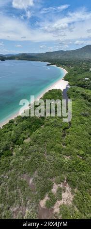 Playa Conchal, annidata a Guanacaste, Costa Rica, vanta conchiglie bianche incontaminate e acque turchesi, rendendolo un paradiso tropicale per gli amanti della spiaggia Foto Stock