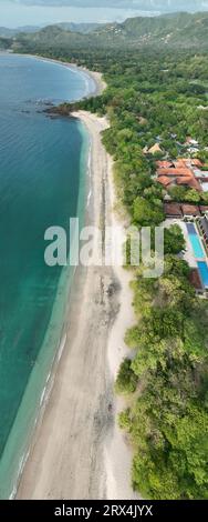 Playa Conchal, annidata a Guanacaste, Costa Rica, vanta conchiglie bianche incontaminate e acque turchesi, rendendolo un paradiso tropicale per gli amanti della spiaggia Foto Stock