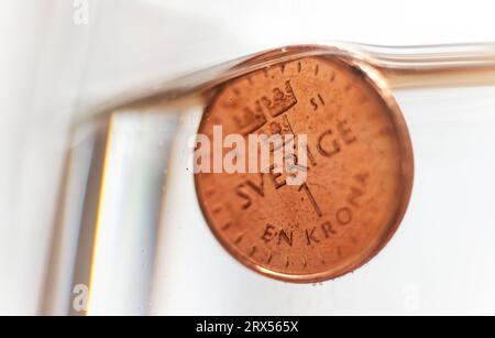 La corona svedese si trova a un livello minimo rispetto all'euro. Questa settimana ha visto un nuovo record storico per la corona svedese. Solo quest’anno, ha perso circa il 7 per cento in valore contro l’euro. Nella foto: Qui una corona che affonda nell'acqua. Foto Stock