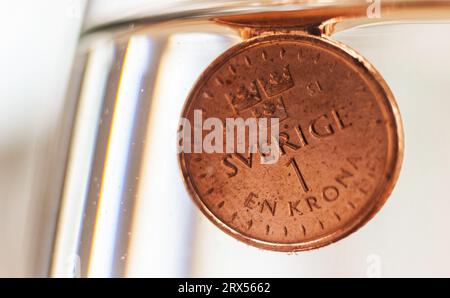 La corona svedese si trova a un livello minimo rispetto all'euro. Questa settimana ha visto un nuovo record storico per la corona svedese. Solo quest’anno, ha perso circa il 7 per cento in valore contro l’euro. Nella foto: Qui una corona che affonda nell'acqua. Foto Stock