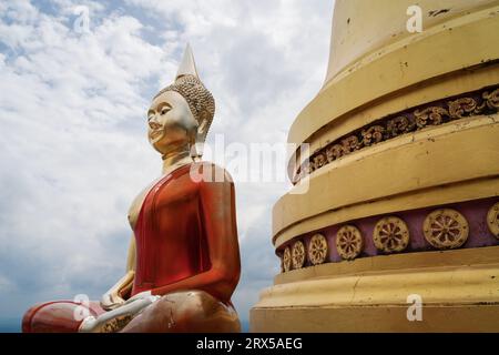 Statua di Buddha di colore dorato seduta presso stupa in cima al Tempel della Grotta della Tigre, Wat Tham sua, a Krabi, Thailandia Foto Stock