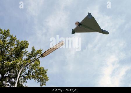 Drone da combattimento Shahed che sorvola il cielo e il fan della città, vista dal basso, attacco di droni su strutture e infrastrutture elettriche, guerra in Ucraina, rendering 3d. Foto Stock