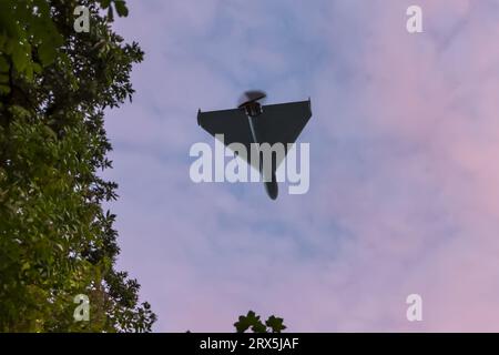 Shahed drone da combattimento che vola sullo sfondo della città e del cielo, vista dal basso, attacco di droni, guerra in Ucraina, Foto Stock