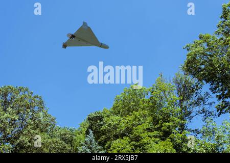 Shahed drone da combattimento che vola sullo sfondo di fan e cielo della città, vista dal basso, attacco droni, guerra Foto Stock