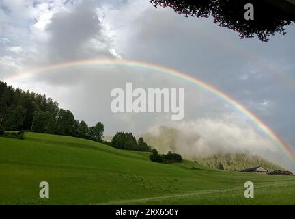 Una volta che la tempesta è finita, un doppio arcobaleno copre la valle con il suo arco, colorando la fine della giornata Foto Stock