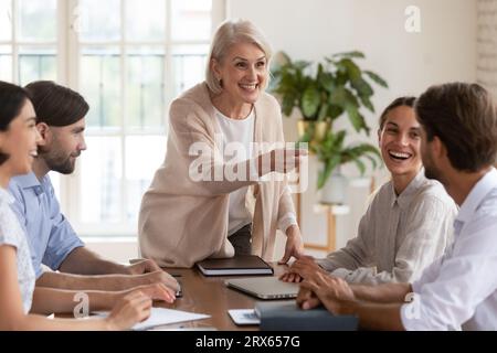 Il personale varia durante la riunione informativa mattutina è lieto di comunicare divertendosi Foto Stock