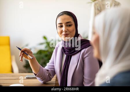 Wedding planner sorridente che discute con un collega Foto Stock