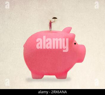 Donna in piedi sopra un salvadanaio gigante con ombrello in mano Foto Stock