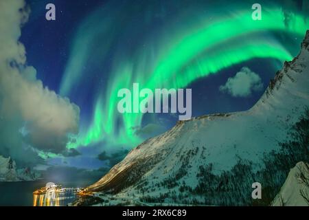 Norvegia, Troms og Finnmark, aurora boreale verde sulle montagne che circondano Oyfjord Foto Stock