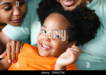 Ragazza sorridente che gioca con madre e padre Foto Stock