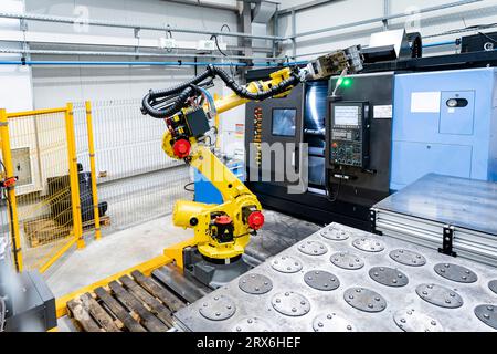 Braccio robotico giallo con macchinari industriali Foto Stock