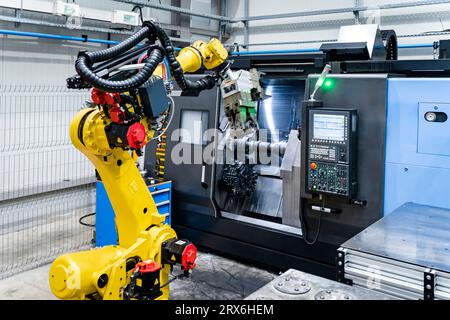 Braccio robotico giallo con macchinari di fabbrica Foto Stock