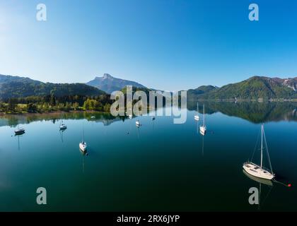 Austria, alta Austria, Loibichl, Drone vista delle barche a vela nel lago Mondsee con la montagna Schafberg sullo sfondo Foto Stock