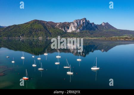 Austria, alta Austria, Loibichl, Drone vista delle barche a vela nel lago di Mondsee con la montagna Drachenwand sullo sfondo Foto Stock