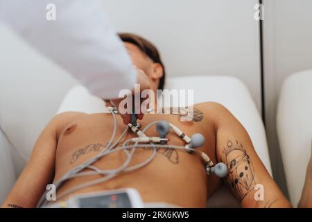 Cardiologo esperto che analizza i risultati dell'elettrocardiogramma, fornendo assistenza sanitaria e trattamento al paziente. Foto Stock