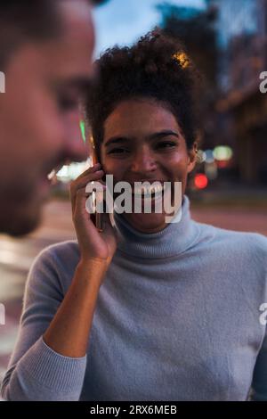 Felice giovane donna che parla su smartphone Foto Stock
