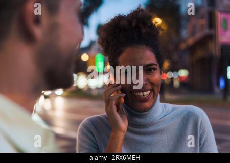 Sorridente giovane donna parlando su smart phone Foto Stock
