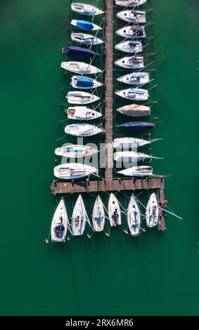 Austria, alta Austria, vista sui droni delle barche a vela ormeggiate lungo il porticciolo sulla riva del lago Mondsee Foto Stock