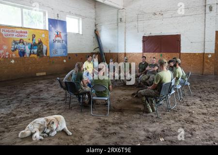 Kiev, Ucraina. 23 agosto 2023. Sessione di terapia di gruppo e discussione sul programma di riabilitazione per il personale militare di ritorno dai campi di battaglia. I soldati delle forze armate ucraine sono sottoposti ad ippoterapia per disturbi da stress post-traumatici derivanti da operazioni militari. Dopo il riposo e la riabilitazione, i soldati torneranno nella zona di guerra. L'ippoterapia, o terapia assistita da cavalli, è un metodo efficace di riabilitazione con i cavalli. È stato riconosciuto dal Ministero della salute dell'Ucraina ed è incluso nei protocolli di trattamento. Credito: SOPA Images Limited/Alamy Live News Foto Stock