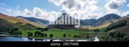 panorama aereo di buttermere guardando a est dalla riva verso i fienili con il luccio e il passo honister, proiettato al sole Foto Stock